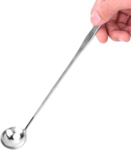 A hand holding a stainless steel spoon with a long handle